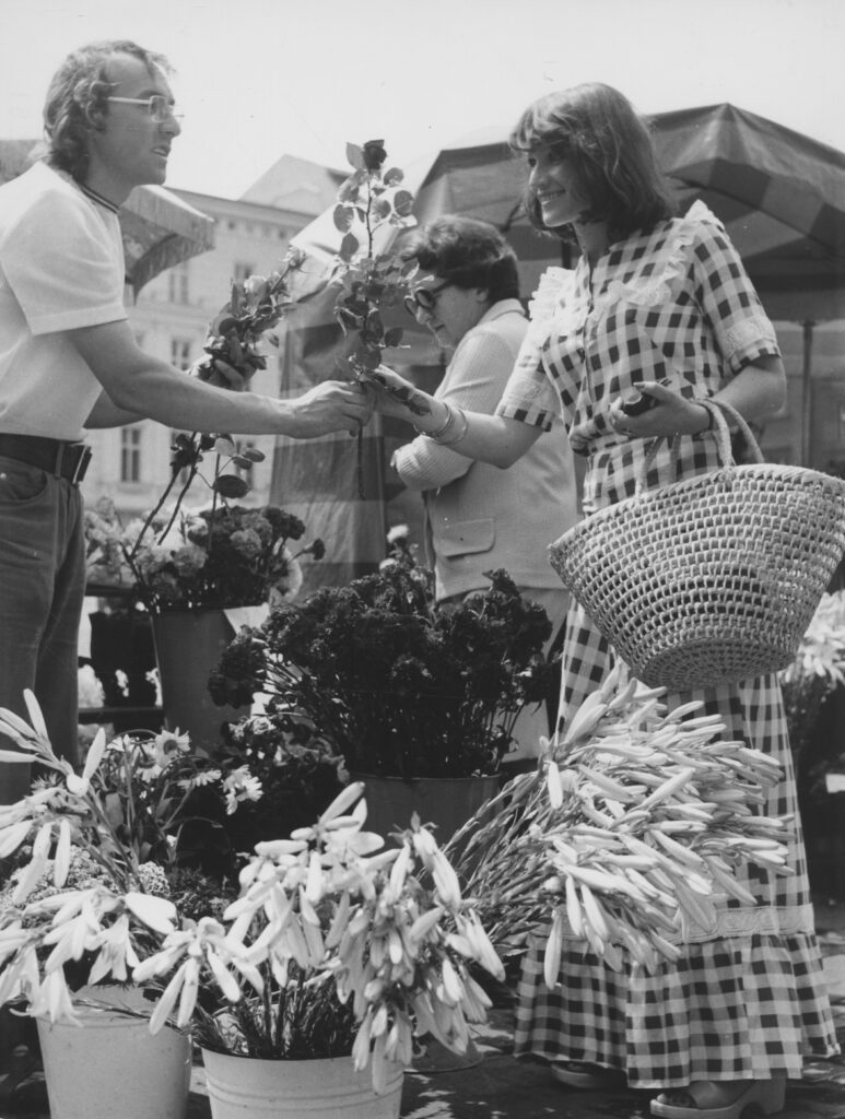 Mężczyzna wręczający kobiecie kwiaty, Plac Solny we Wrocławiu 1975. Fot. S. Kokurewicz